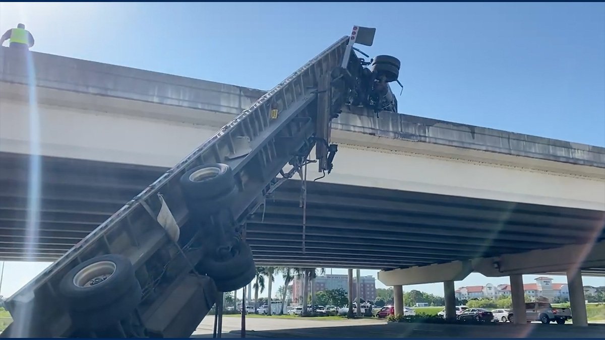 Semi left dangling from I-75 overpass after fiery Lee County crash